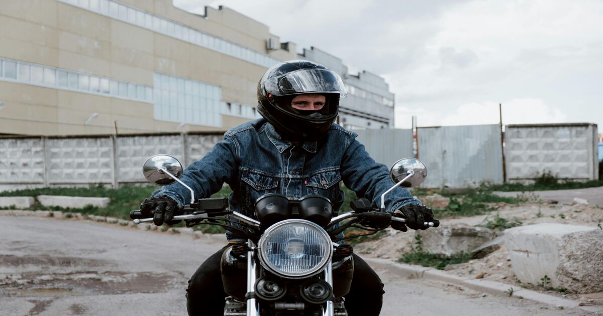 A man on a bike wearing one of the most common types of motorcycle helmets.