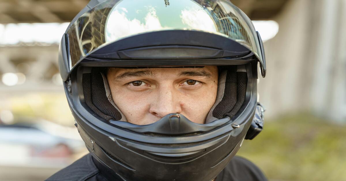 A close up image of a person wearing a full-face helmet with the visor up.